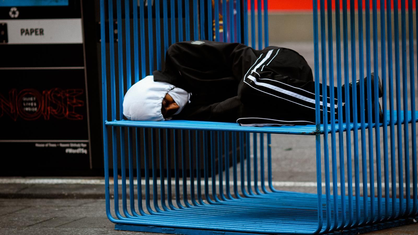 Person sleeping unsheltered on a bench