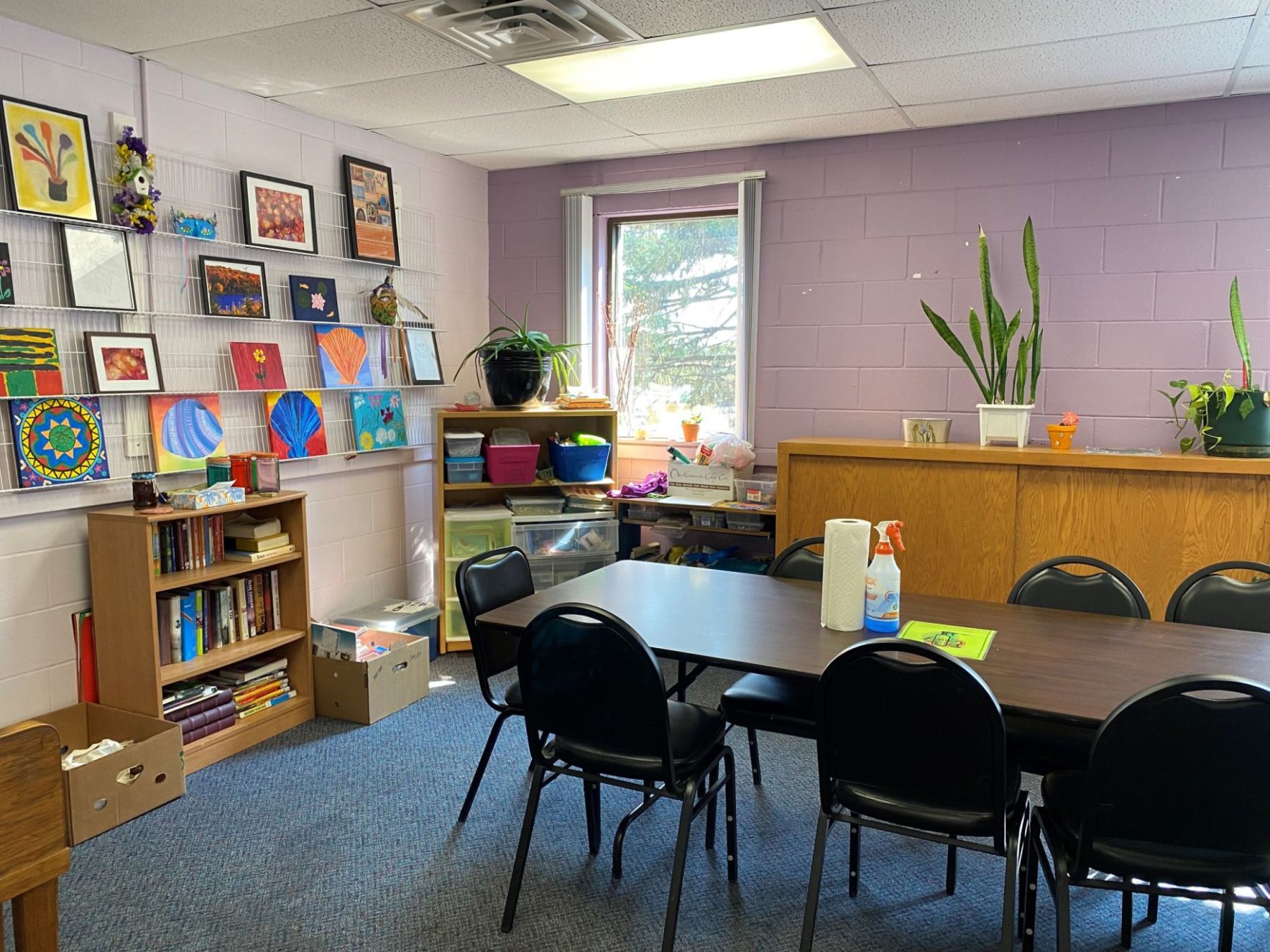 Room with a long table and chairs and art on the wall