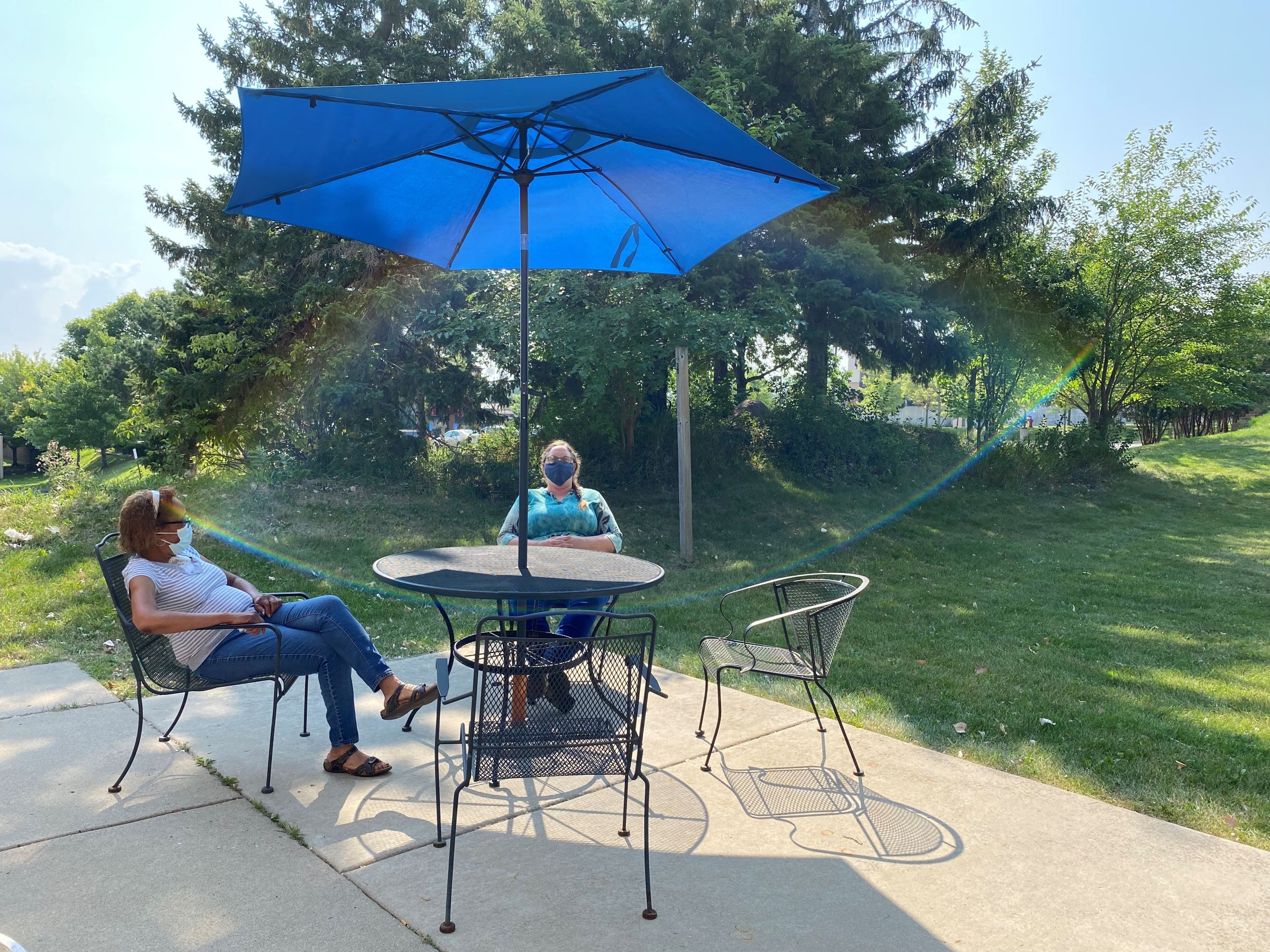 Two people sitting at a outdoor table in a backyard